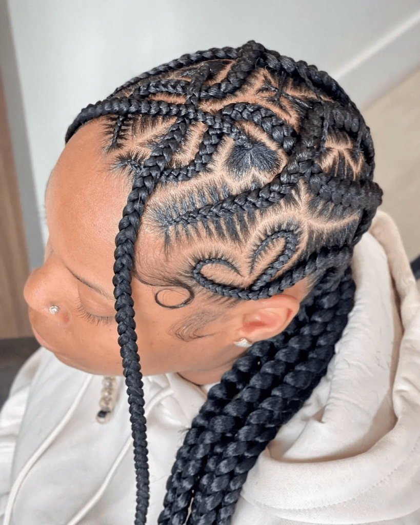 A woman with a nose ring wearing a cross of cornrows