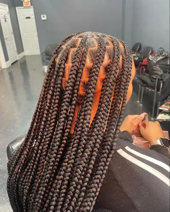 Side view of a woman with beautiful medium no-less braids.