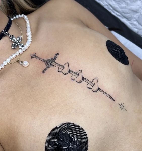 Man shows off sword tattoo design