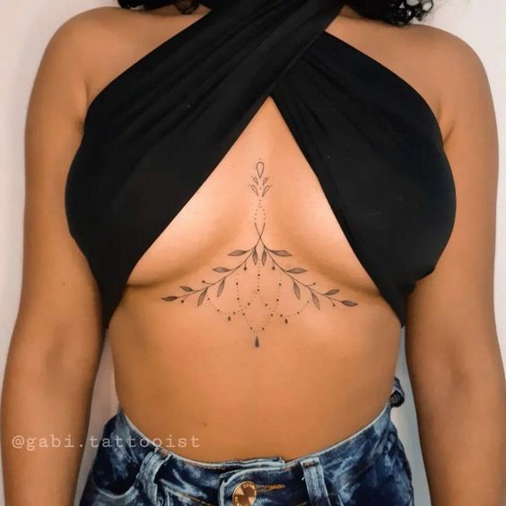 Front view of woman rocking botanical sternum tattoo design.
