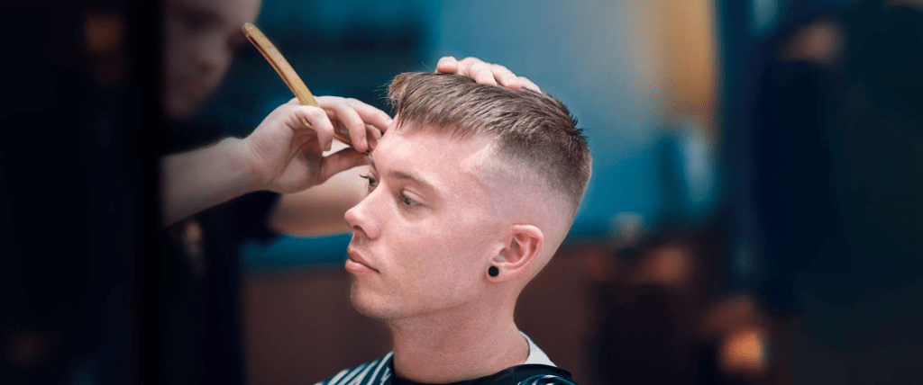 O corte de cabelo estiloso para cada formato de rosto 14 Foto de um homem usando franja romba Low Taper com parte superior texturizada