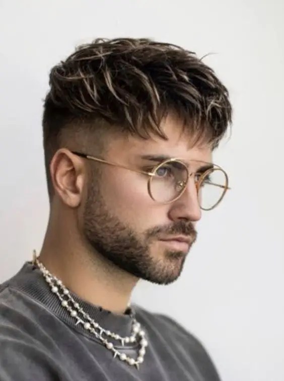 O corte de cabelo estiloso para cada formato de rosto 24 Foto de um homem de óculos usando uma elegante franja cônica baixa