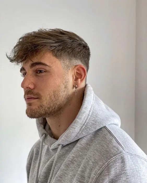 O corte de cabelo estiloso para cada formato de rosto 23 A imagem de um homem com capuz e franja baixa
