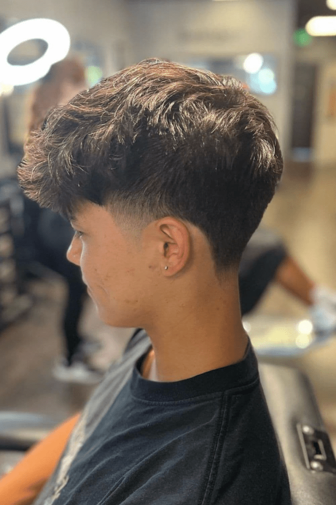 O corte de cabelo estiloso para cada formato de rosto 21 Vista lateral de um menino exibindo sua conicidade baixa