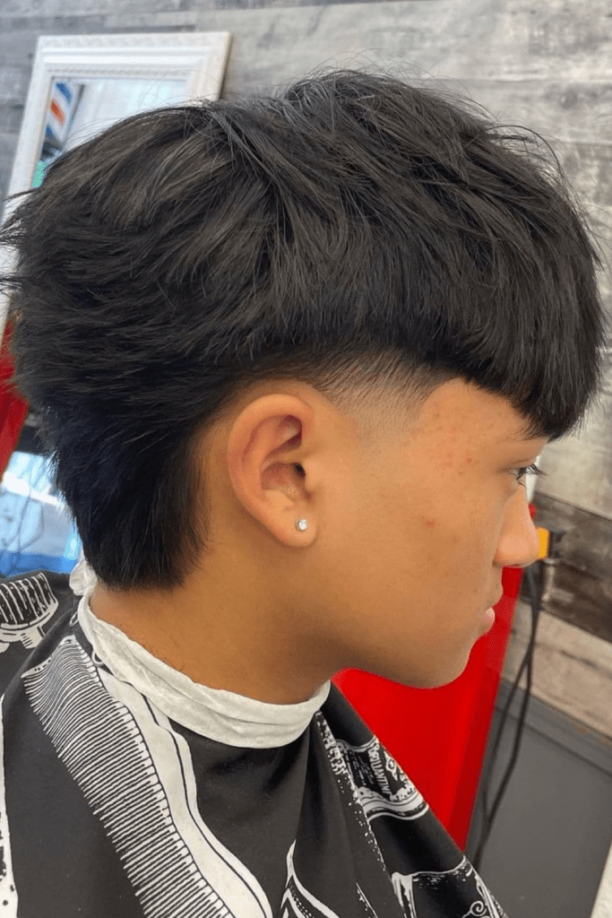 O corte de cabelo estiloso para cada formato de rosto 19 Vista lateral de um homem asiático usando o penteado cônico baixo
