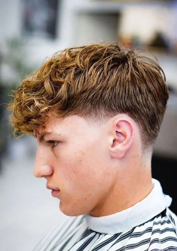 O corte de cabelo estiloso para cada formato de rosto 18 Vista lateral de um menino usando o penteado icônico