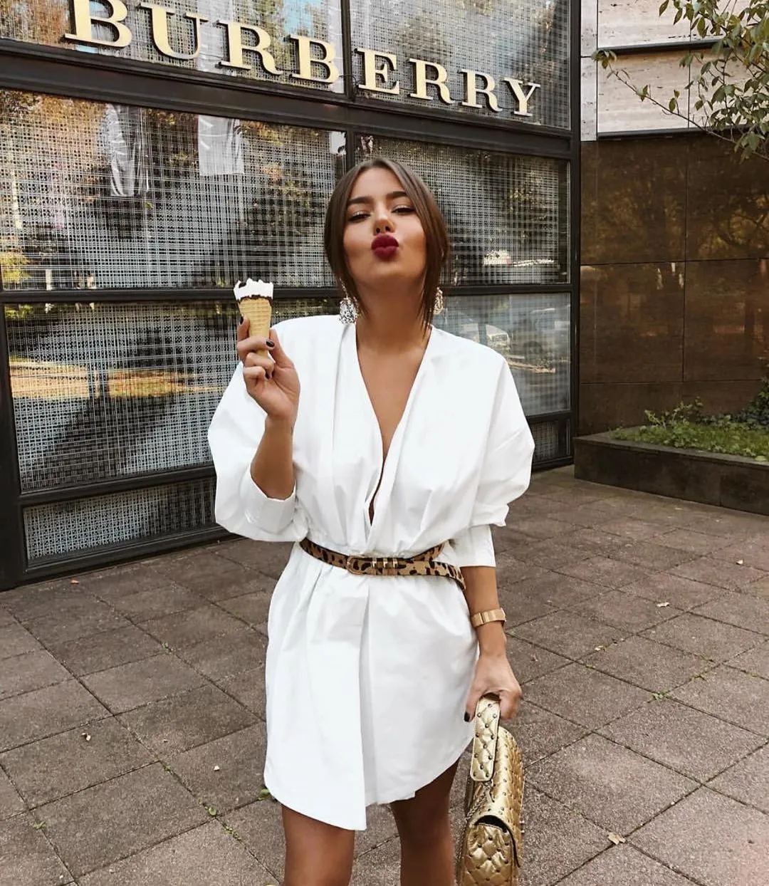 Woman with ice cream wearing a belt on her white shirt dress