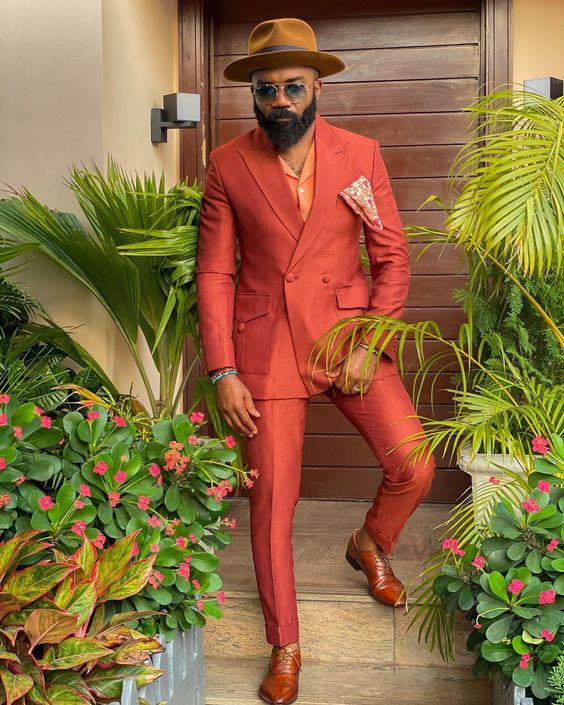 A noble igwe in a burnt orange suit and hat