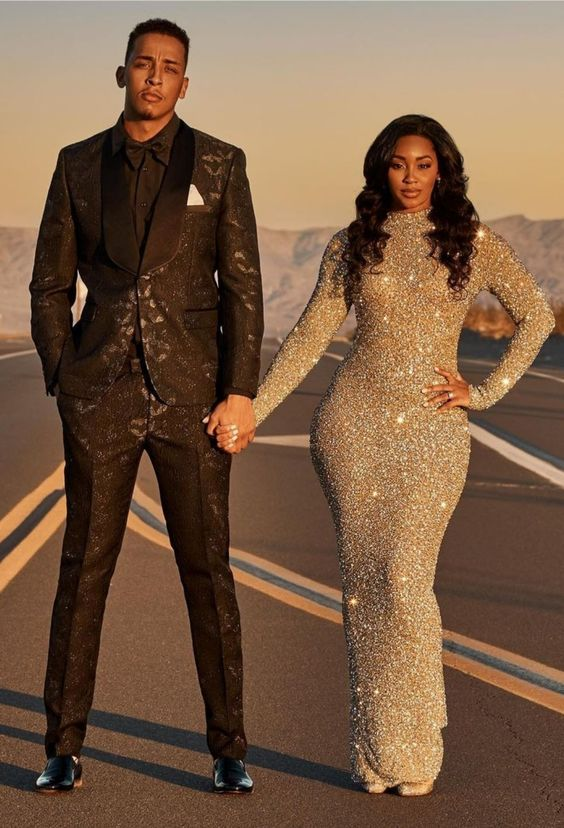 A man in a black suit and a woman in a sequin dress