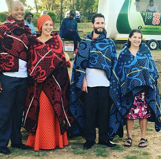 Two smiling couples in traditional Sotho costumes