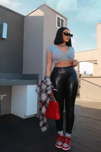 lady wearing sneakers with leather leggings and crop top