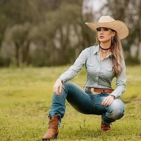 cowgirl squatting on green grass