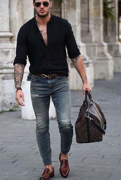 Man wearing black shirt over jeans with bag and other fashion accessories