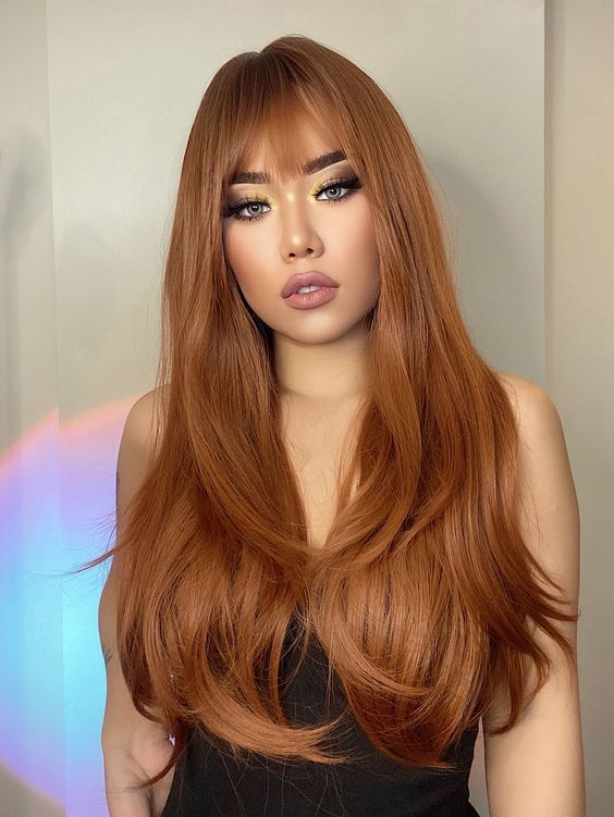 Woman wearing brown wig with bangs