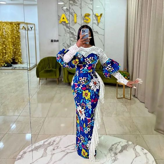 Woman taking mirror selfie wearing ankara and lace combination