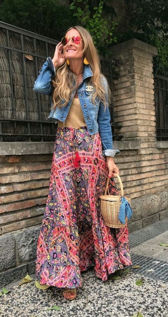 Woman layering jeans jacket over bohemian outfit