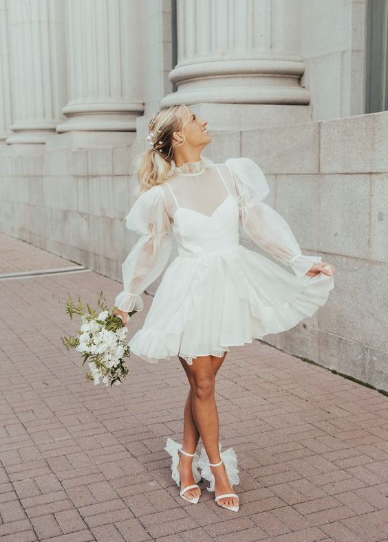 bride in short flared wedding dress holding flowers