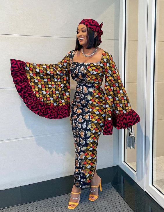 Smiling woman in mixed ankara print dress with statement sleeves