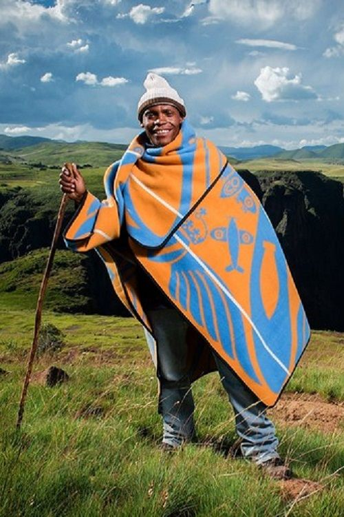 Smiling man with stick in traditional Sotho costume