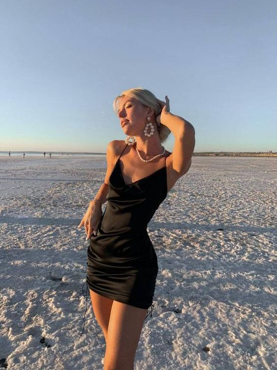 Woman wearing little black dress on the beach