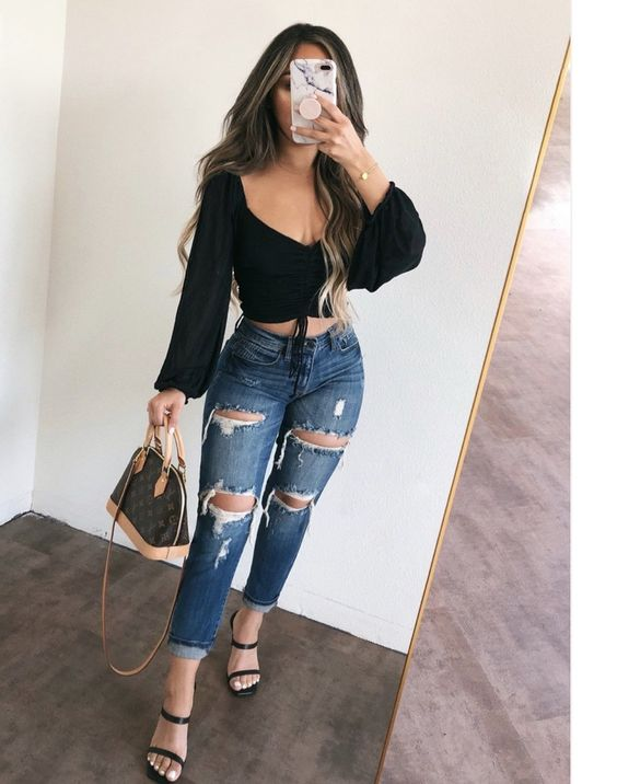 Woman taking a mirror image with a black top and jeans
