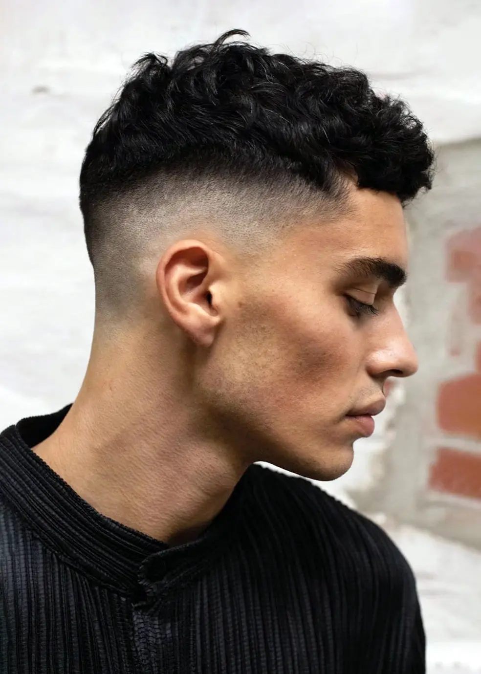 side view of man wearing short hair mid fade