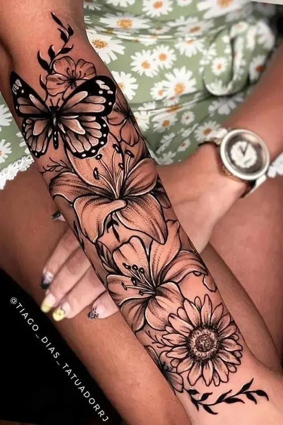 a butterfly and flower theme sleeve tattoo a lady's arm