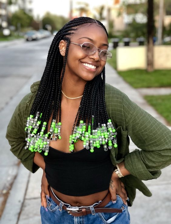 Smiling woman wearing mid-length beaded Fulani braid