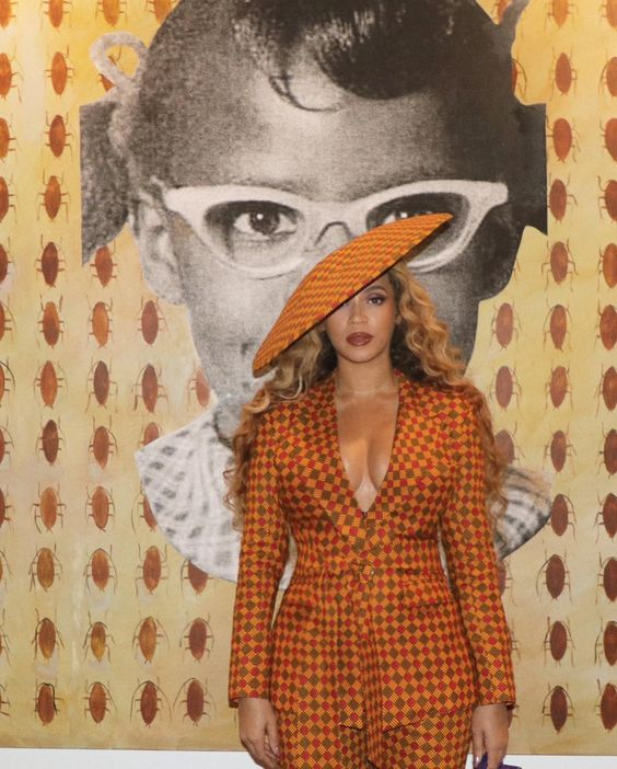 Beyoncé in a matching suit with an Ankara hat