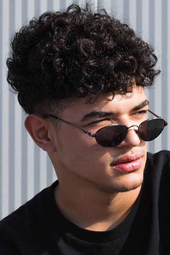 Man rocking curly hairstyle for men with sunglasses