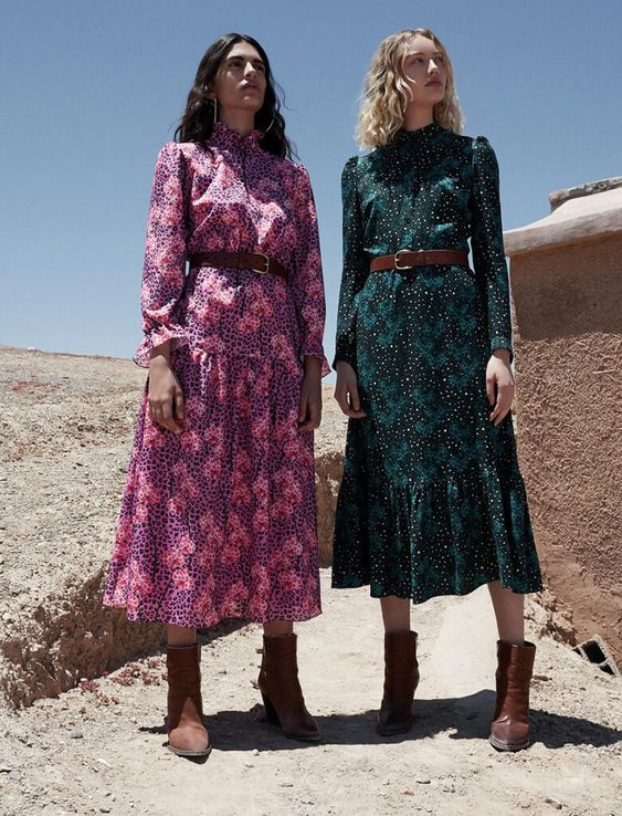 Two women wearing cowboy boots and prairie dresses