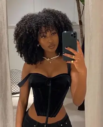 lady wearing with natural wavy hair taking mirror selfie
