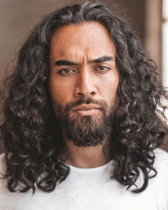 man wearing long curly hairstyle for men