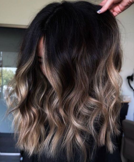 Woman with dark hair and ombre blonde highlights