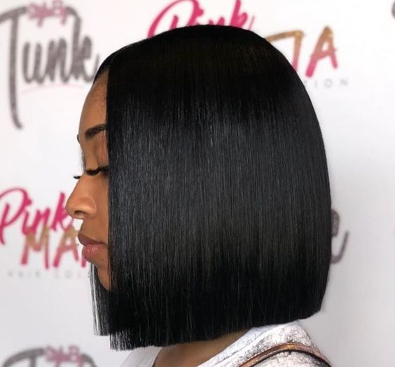 Black woman posing side view while rocking a blunt cut bob wig