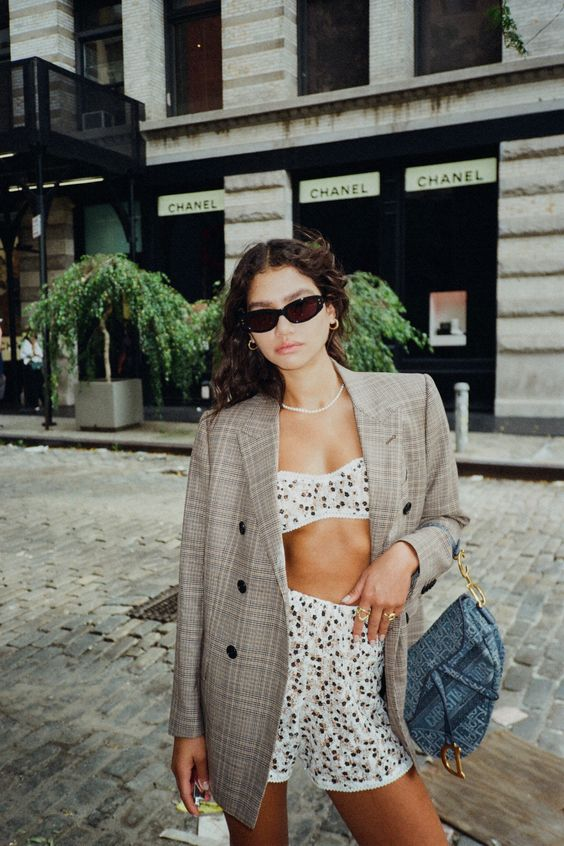 A woman wearing a jacket over a two-piece outfit