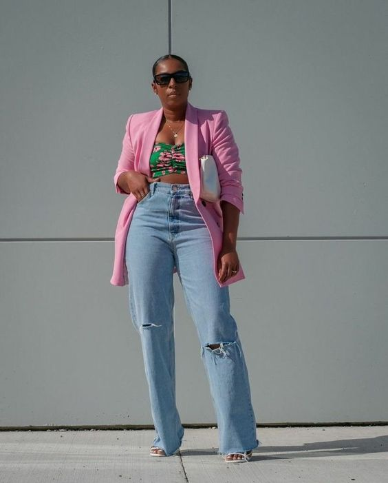 Woman wearing jeans, sunglasses and pink jacket