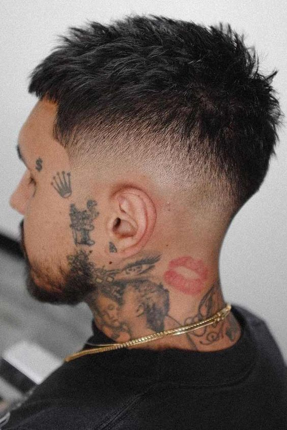 tattooed man wearing short hair fade