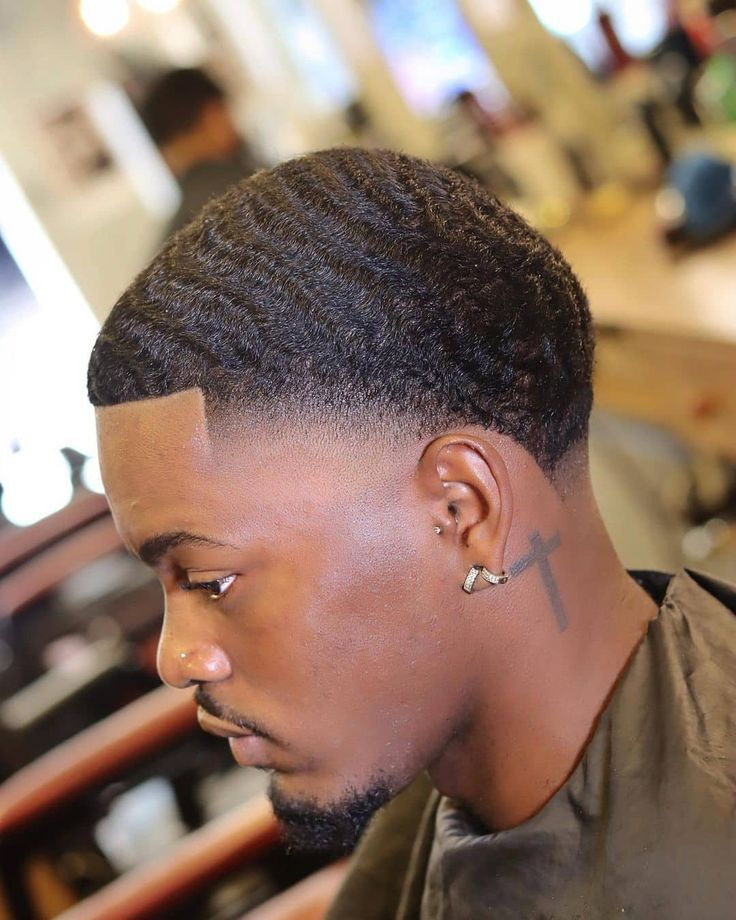 Man with cross tattoo and short hair rocking fade in waves