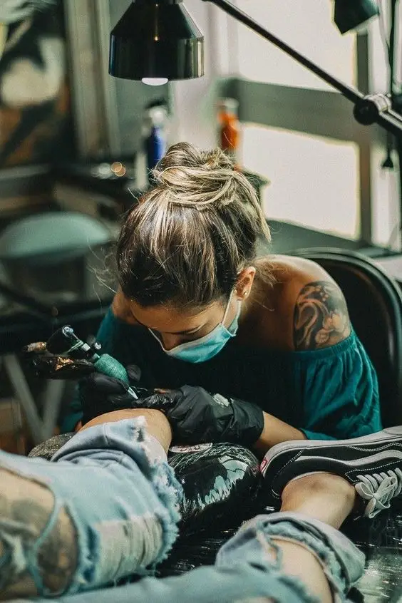 a tattoo artist drawing a sleeve tattoo