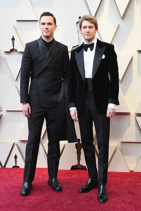 Two men dressed in suits and tuxedos