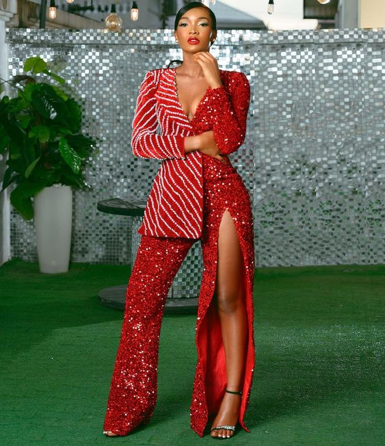 Woman in sparkly red suit with thigh slit