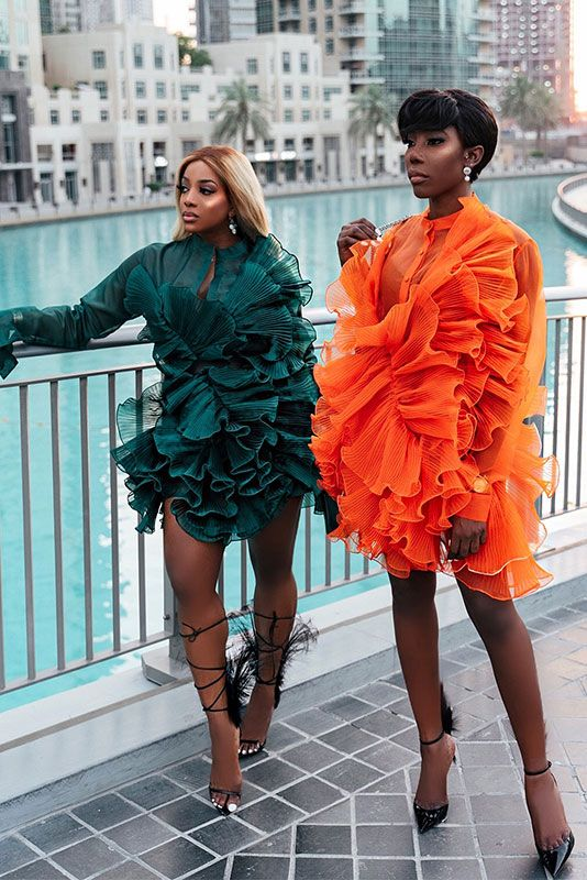 Two women wearing green and orange chic fashion styles