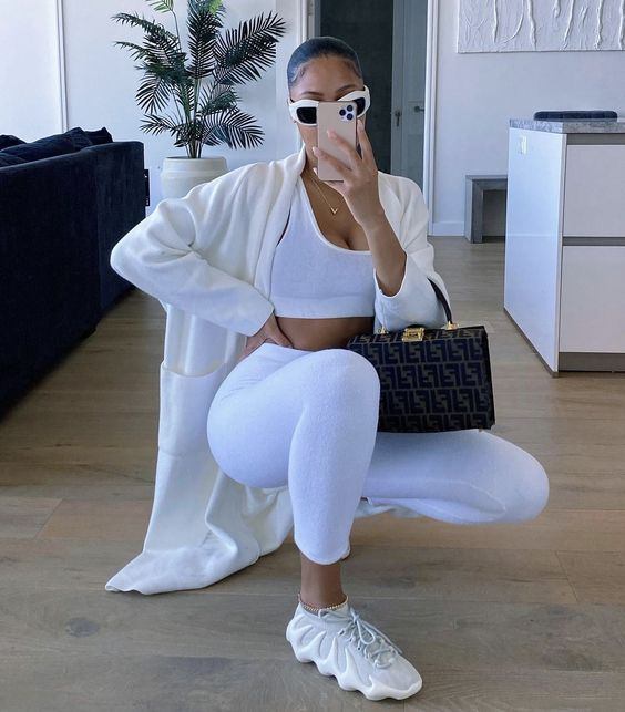Woman wearing all white chic fashion style with white sneakers
