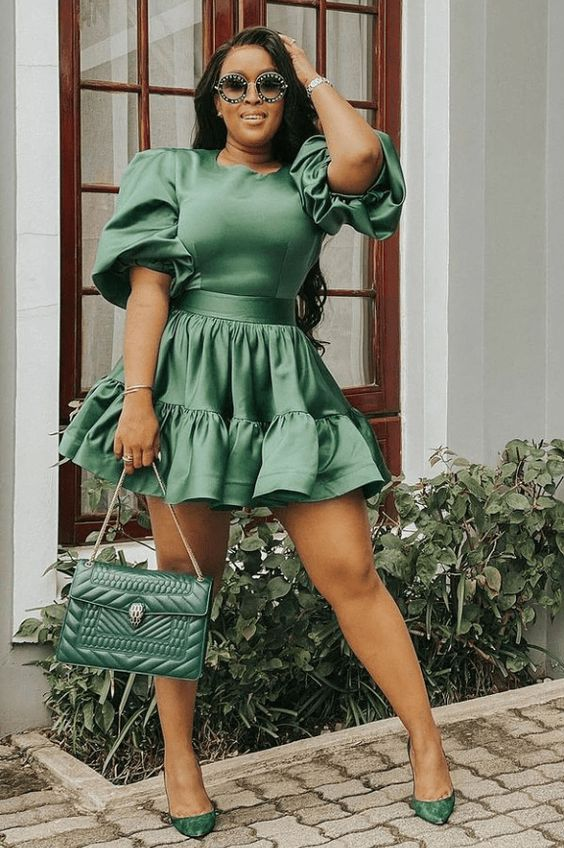 Woman wearing matching handbag and shoes and green dress