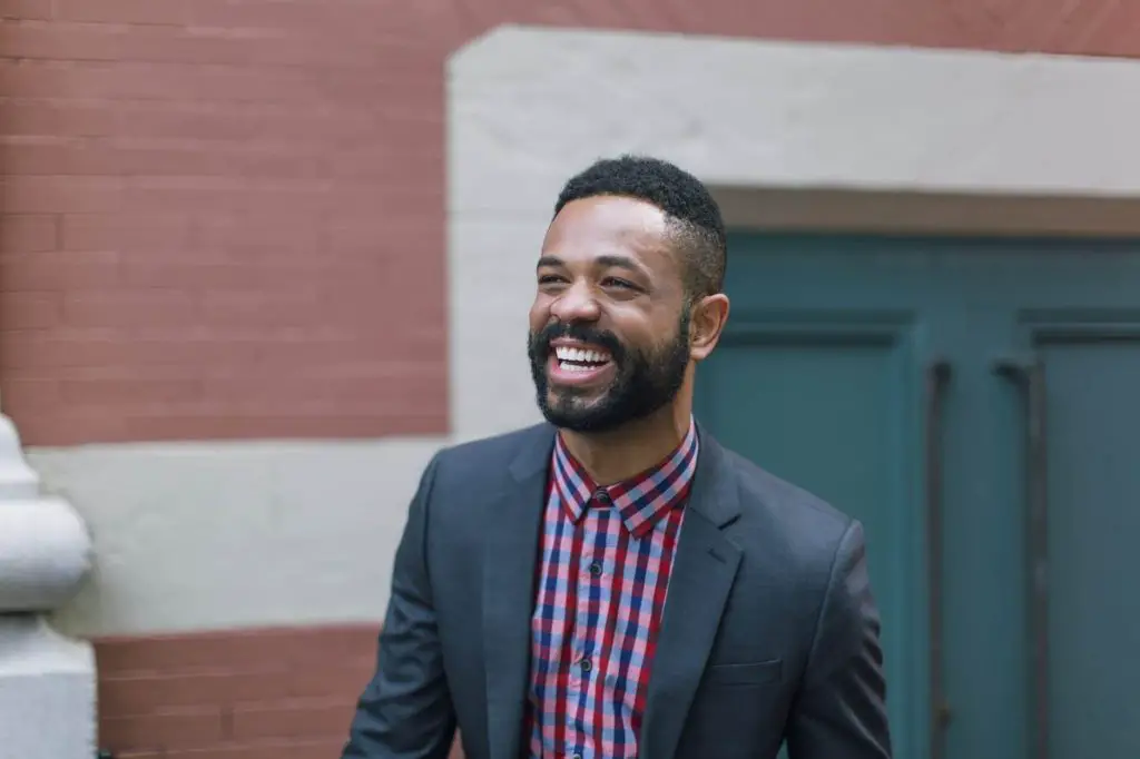 smiling man in a grey notch lapel suit